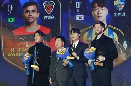 울산 현대 김영권이 4일 서울  롯데호텔월드에서 열린 2023 프로축구 K리그 대상 시상식에서 베스트11에 선정된 뒤  같은 팀 설영우, 포항 스틸러스 그랜트와 사진을 찍고 있다. 연합뉴스