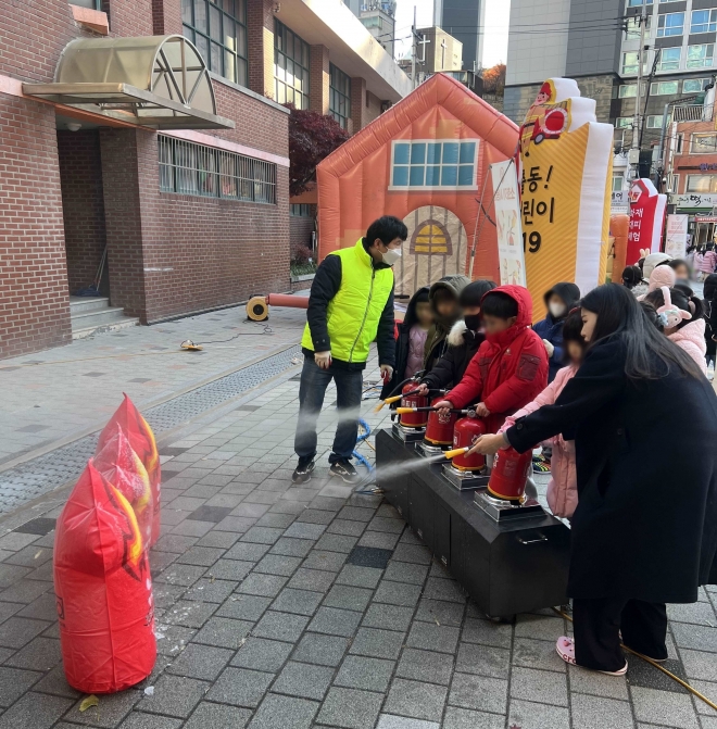 지난달 24일 서울 마포구 공덕초등학교에서 진행된 찾아가는 어린이 안전 체험 교육에서 어린이들이 소화기를 분사해 불을 끄는 체험을 하고 있다. 2023.12.5 마포구 제공