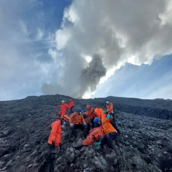 인도네시아 구조대원들이 5일(현지시간) 서수마트라주 아감에 있는 마라피 화산 분출에 목숨을 잃은 이의 시신을 찾아내 산 아래로 운반할 채비를 하고 있다. 인도네시아 구조당국 제공 로이터 연합뉴스