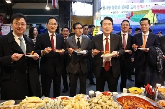 윤석열 대통령이 6일 부산 중구 깡통시장에서 재계 총수들과 함께 떡볶이 튀김 빈대떡을 맛보고 있다. 오른쪽 부터 김동관 한화그룹 부회장, 구광모 LG그룹 회장, 윤 대통령, 조현준 효성그룹 회장, 이재용 삼성전자 회장, 최재원 SK수석부회장. 연합뉴스