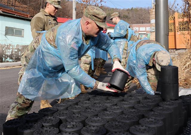 미군 장병들의 ‘사랑의 연탄’ 배달  13일 오전 경기 동두천 상패동 일대에서 열린 ‘사랑의 연탄나눔’ 행사에서 미2사단 210야전포병여단 장병들이 취약계층에 전달할 연탄을 나르고 있다. 이날 열린 행사에서 미군 장병 130여 명과 동두천시자원봉사센터 관계자들은 상패동 취약계층 9가구에 연탄 2,500장을 직접 배달했다. 2023.12.13 뉴스1