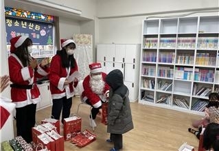 지난해 청소년 산타들이 지역아동센터에서 아동에게 선물을 전달하고 있다. 송파구 제공