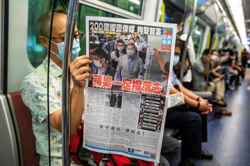 홍콩 시민이 지난 2020년 지하철에서 빈과일보를 읽고 있다. 지미 라이가 발행한 빈과일보는 중국 지도부에 대한 비판으로 2021년 폐간됐다. 홍콩 AFP 연합뉴스