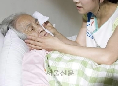 경기도의 한 요양보호시설에서 요양보호사가 노인 환자를 돌보고 있다. 서울신문 DB