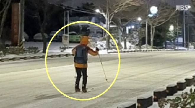 폭설이 내린 제주의 한 도로에서 스키 장비를 장착하고 이동하는 남성이 포착됐다. JIBS 보도화면 캡처