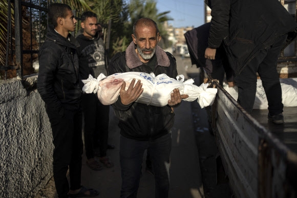 성탄 시즌을 앞둔 오늘도 팔레스타인 가자지구에는 이스라엘군의 공습 희생자들이 쏟아지고 있다. 한 남성이 22일(현지시간) 가자지구 남부 라파 병원에서 이스라엘 공습에 희생된 손주 시신을 옮기고 있다. 라파 AP 연합뉴스