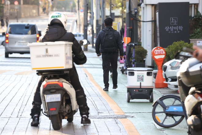 서울 강남 테헤란로 일대에서 자율주행 배달로봇 ‘뉴비’와 배달기사가 도로를 오가고 있다.  연합뉴스