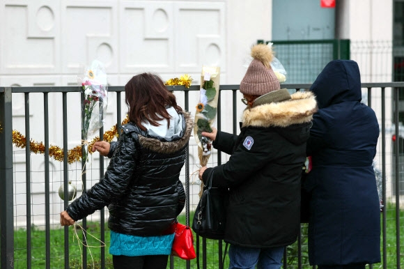 프랑스 파리 외곽 모(Meaux) 시에 있는 작은 아파트 앞에 26일(현지시간) 이 집에 살던 35세 엄마와 네 자녀가 살해된 것을 애도하며 사람들이 장식과 인형을 매달고 있다. 모 AFP 연합뉴스