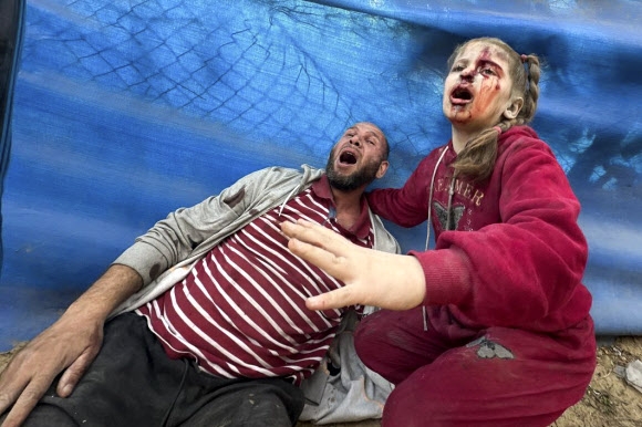 부녀로 보이는 팔레스타인인들이 28일(현지시간) 가자지구 중부 알 자와이다에 이스라엘군 공습 피해를 당한 직후 절규하고 있다. 알자와이다 AP 연합뉴스