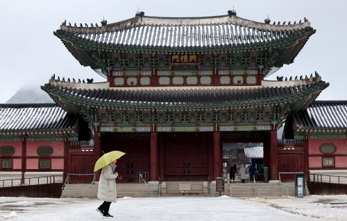 아침까지 약한 눈비가 이어진 31일 오전 서울 종로구 경복궁을 찾은 관광객이 설경을 바라보고 있다. 뉴스1