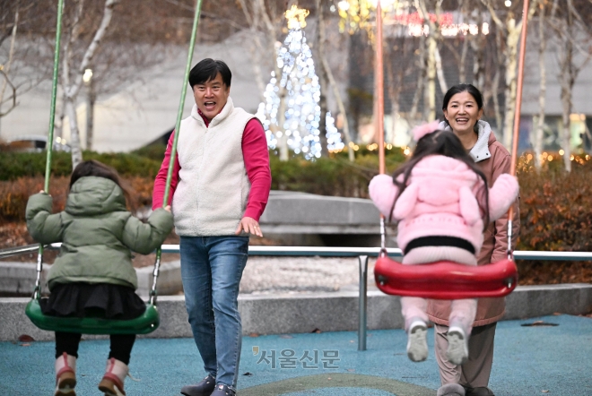 안난영·김수창씨 부부가 지난달 26일 집 근처 놀이터에서 그네를 타는 두 딸을 바라보며 미소 짓고 있다. 3년을 함께한 이들은 핏줄은 아니지만 서로를 마주 보면 웃음이 새어 나오는 그런 평범한 가족이 됐다. 도준석 전문기자