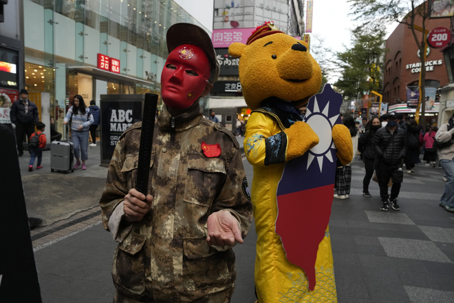 지난 7일(현지시간) 대만 타이페이에서 친중 세력 집권을 반대하는 시위에서 참가자들이 군복과 곰돌이 푸 탈을 쓰고 있다. 한때 시진핑 중국 국가주석에게는 푸라는 별명이 붙기도 했다. 타이베이AP 연합뉴스