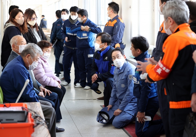 기시다 후미오(오른쪽 네 번째) 일본 총리가 14일 노토반도 지진 피해지역인 이시카와현 스즈시 피난소에서 왼쪽으로 고개를 돌려 주민 얘기를 경청하고 있다.  스즈 EPA 연합뉴스