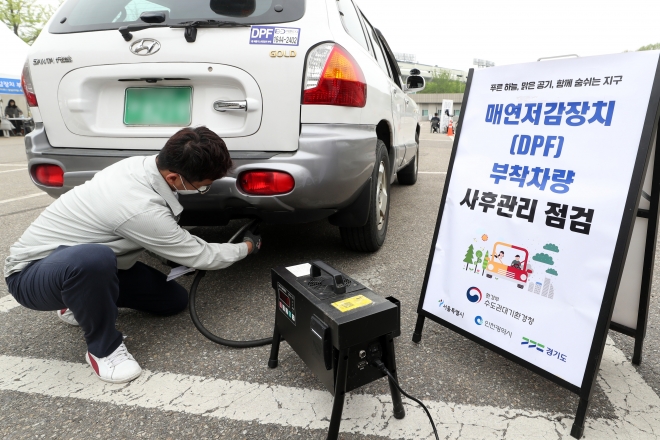 서울시와 협력업체 직원이 25일 오후 서울 송파구 잠실종합운동장 제1주차장에서 배출가스저감장치(DPF)를 장착한 노후 경유차량의 매연을 측정하고 있다. 서울신문DB