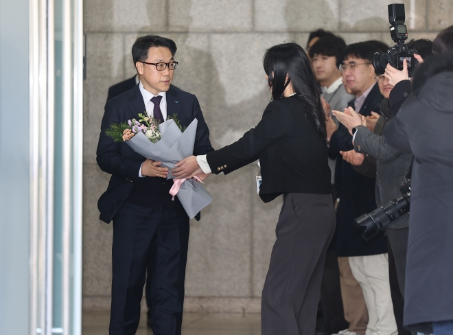 김진욱 고위공직자범죄수사처장이 19일 오전 정부과천청사 공수처에서 열린 이임식을 마친 뒤 건물을 나서며 직원들로부터 꽃다발을 받고 있다. 2024.1.19 연합뉴스