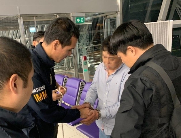 택시기사를 살해하고 태국으로 달아난 A씨가 태국공항에서 검거되고 있다. 아산경찰서 제공