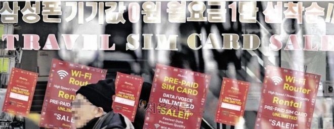 단말기 할인 광고가 붙은 서울의 한 이동통신대리점 앞을 한 시민이 지나가고 있다. 정부는 22일 ‘이동통신 단말장치 유통구조 개선에 관한 법률’(단통법)을 폐지해 이동통신사의 휴대전화 단말기 지원금 상한 등을 없애겠다고 밝혔다. 홍윤기 기자