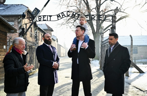 일론 머스크(왼쪽 세번째) 테슬라 최고경영자가 22일 아들을 목말 태운 채 유럽 ​​유대인 협회의 랍비 메나헴 마골린 등과 함께 폴란드 아우슈비츠의 유대인 수용소를 돌아보고 있다. 로이터 연합뉴스