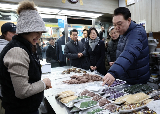 윤석열 대통령이 25일 경기도 의정부시 의정부제일시장을 찾아 떡 가게에서 떡을 고르고 있다. 2024.1.25 연합뉴스