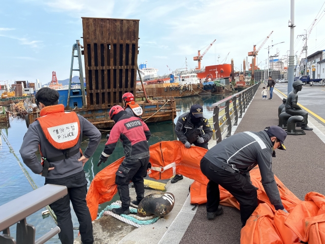 지난해 11월 26일 부산 영도구 봉래동 물양장 한 선박에서 기름 유출 사고가 발생해 부산해경 관계자들이  오일펜스를 설치하고 있다. 부산해경 제공