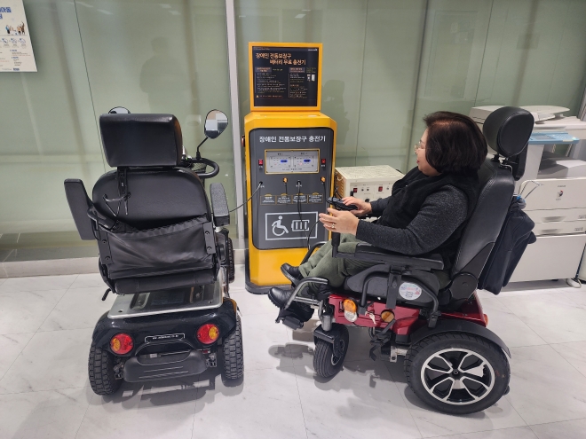 서울 노원구 주민이 전동 보장구 급속 충전기에서 이동기기를 충전하고 있다. 노원구 제공