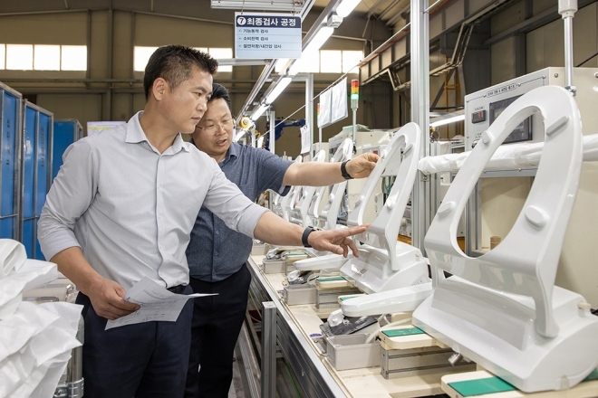 충남 아산에 있는 비데 전문기업 ‘에이스라이프’에서 에이스라이프 직원(왼쪽)과 삼성전자 스마트공장 담당자(오른쪽)가 비데 제품의 품질 상태를 점검하고 있다. 삼성전자 제공