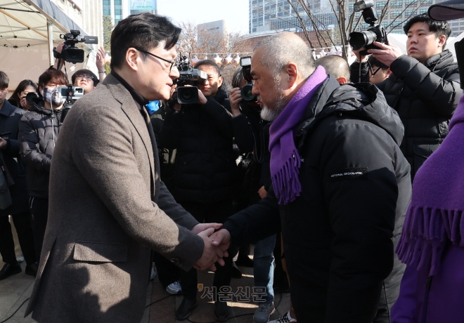 홍익표(왼쪽) 더불어민주당 원내대표가 30일 서울 중구 서울광장에 마련된 10·29 이태원 참사 희생자 합동분향소에서 이정민 유가족협의회 운영위원장을 만나 악수하고 있다. 2024.1.30 홍윤기 기자