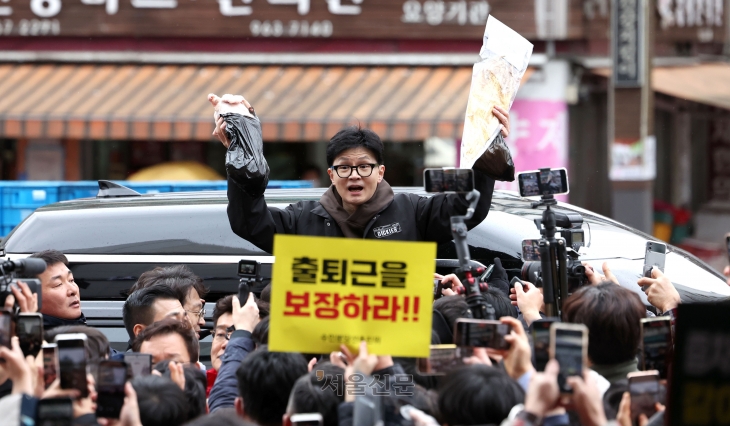 한동훈 국민의힘 비상대책위원장이 설 명절 연휴를 나흘 앞둔 5일 서울 동대문구 청량리 청과물시장·경동시장을 방문해 구매한 상품을 들어보이며 시민들과 인사를 나누고 있다.2024.2.5 안주영 전문기자