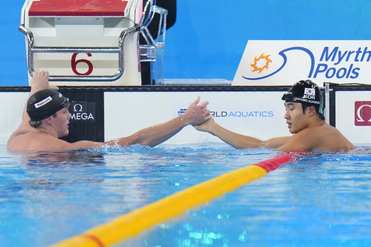 황선우(오른쪽)가 14일(한국시간) 카타르 도하 어스파이어돔에서 열린 2024 국제수영연맹 세계선수권대회 경영 남자 자유형 200ｍ 결승에서 우승한 뒤, 루크 홉슨의 축하를 받고 있다. 2024.2.14 도하 AP=연합뉴스