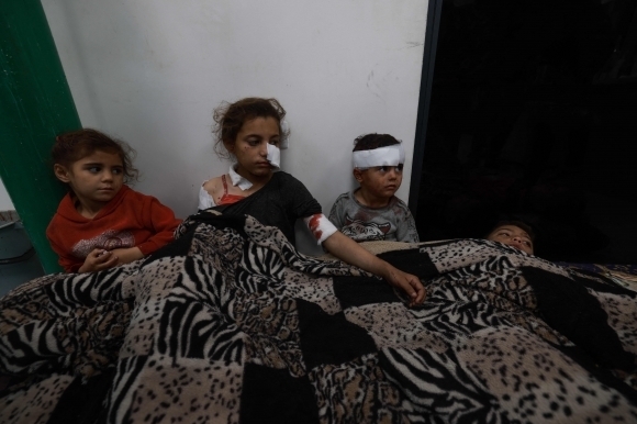 12일(현지시간) 팔레스타인 가자지구 주민의 마지막 피란처인 최남단 도시 라파에서 얼굴과 팔 등에 부상을 입은 한 소녀가 다른 동생들을 위로하고 있다. 이스라엘군은 팔레스타인 무장정파 하마스 대대 일부가 라파에 주둔해 있다면서 미국 등 국제사회의 반대에도 이날 새벽 주민들이 잠든 시간 라파 일대를 타격해 최소 37명이 사망했다.라파 AFP 연합뉴스
