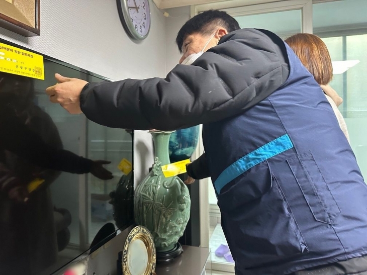 서울 은평구 관계자가 체납 징수를 위해 체납 가정을 방문해 이른바 ‘압류딱지’인 압류 안내서를 붙이고 있다. 은평구 제공