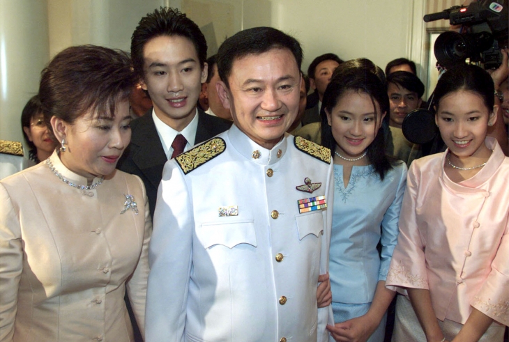FILE PHOTO: Thailand‘s Prime Minister Thaksin Shinawatra (C) and his family pose for group pictures after he received a royal decree by King Bhumibol Adulyadej appointing him as prime minister in Bangkok February 9, 2001.   SS/DL/File Photo