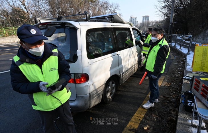수도권에 첫 미세먼지 비상 저감조치가 발령된 지난해 12월 28일 서울 양천 서부트럭터미널 인근 도로에서 공무원들이 노후 경유 차 대상 배출가스 단속을 하고 있다. 도준석 기자