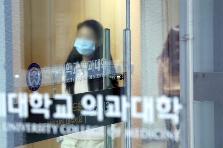 정부의 의대 정원 증원 정책에 반발하는 의과대학 학생들이 20일 동맹 휴학 등 집단행동을 하기로 결의한 가운데 19일 서울의 한 대학 의과대학에서 학생들이 걸어가고 있다. 연합뉴스