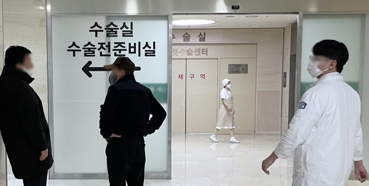 전공의들의 대규모 사직으로 의료 공백이 현실화하는 가운데 21일 서울의 한 대형병원 수술실 앞에서 환자 보호자들이 대기하고 있다. 연합뉴스