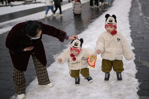 중국인 가족이 눈이 내린 21일 베이징 자금성 나들이를 하고 있다. 베이징 AFP 연합뉴스