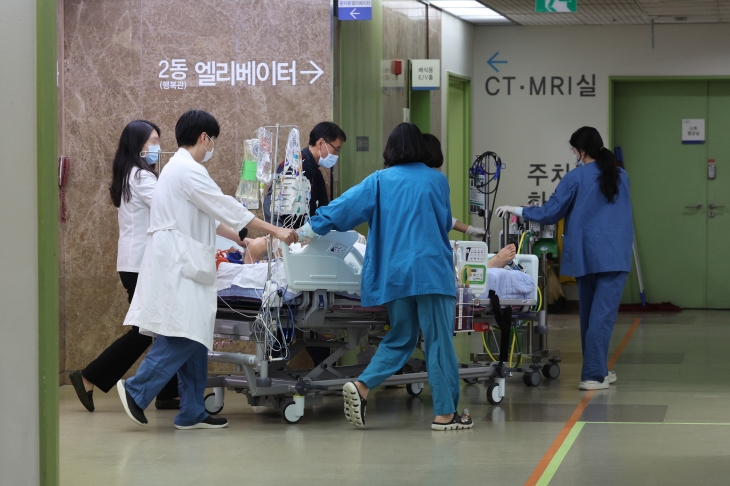 정부가 보건의료재난 위기경보를 최상위 단계인 ‘심각’으로 상향한 23일 서울의 한 대학병원에서 병원관계자가 환자를 옮기고 있다. 연합뉴스