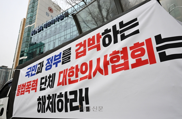 전공의 복귀 시한을 하루 앞둔 28일 서울 용산 대한의사협회 앞에서 한 시민이 의협 해체를 요구하는 현수막을 걸고 있다.  도준석 전문기자