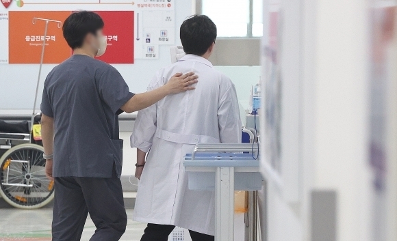 전공의 집단이탈이 장기화하는 가운데 27일 대구 한 대학병원 응급실에서 PA간호사가 의사의 등을 토닥이고 있다. 연합뉴스