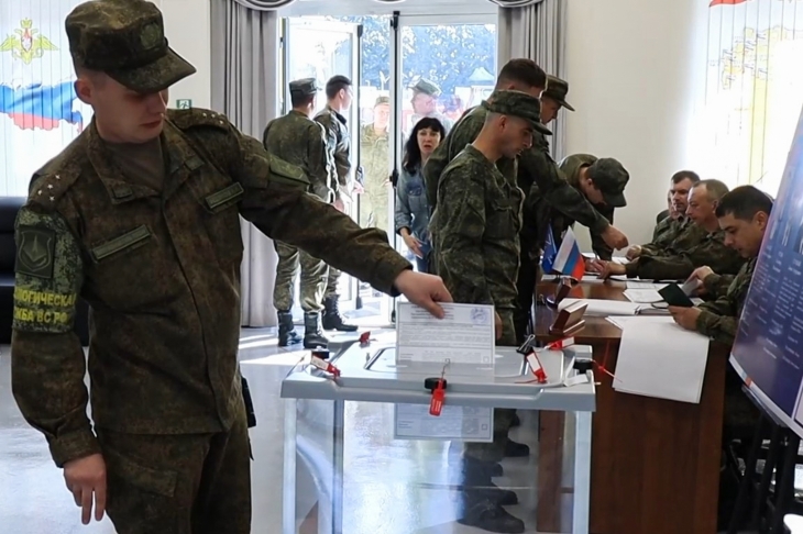 13일(현지시간) 시리아에 있는 러시아 크메이밈 공군 기지에서 군인들이 러시아 대통령 선거 사전 투표에 참여하고 있다. 투표함은 투명하고 투표용지도 접지 않은 채 넣어지는 모습이다. 2024.3.13 러시아 국방부