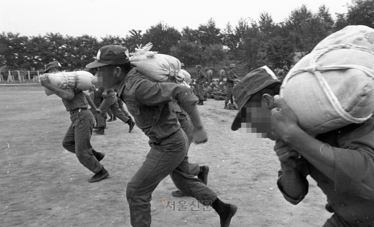 80년 8월 14일 삼청교육대에서 수감자들이 무거운 모래포대를 들고 뛰고 있다.  1980.08.14 서울신문 사진창고
