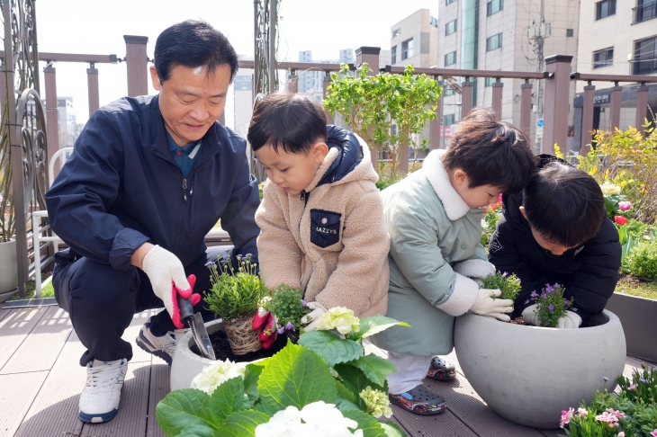 이승로 성북구청장이 20일 성북구청 앞 바람정원에서 어린이집 아이들과 함께 꽃을 심고 있다.   성북구 제공