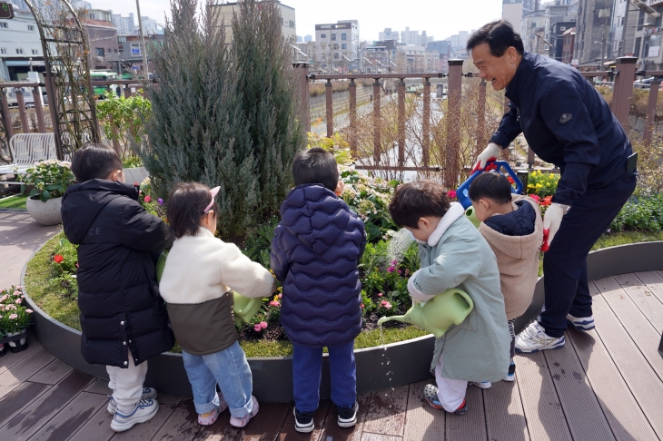 이승로 성북구청장이 20일 성북구청 앞 바람정원에서 어린이집 아이들과 함께 봄 꽃을 심고 있다.   성북구 제공