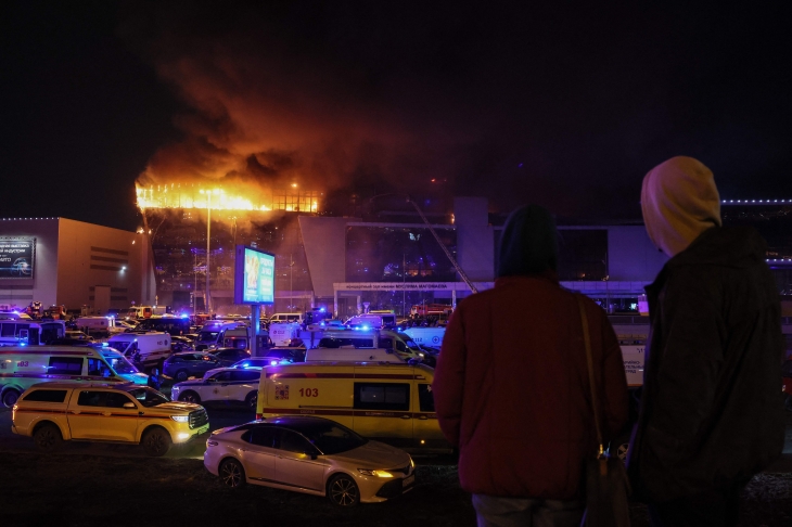 22일(현지시간) 무차별 총격 사건이 벌어진 러시아 모스크바 외곽 대형 콘서트장에서 화염이 치솟고 있다. 외부에는 구급차가 부상자를 이송하기 위해 대기 중이다. 2024.3.23 AFP 연합뉴스
