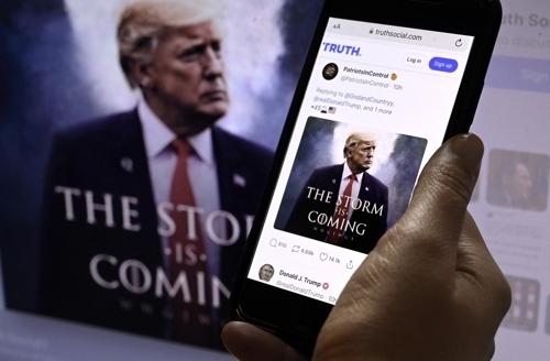 도널드 트럼프 전 미국 대통령이 2022년 9월 워싱턴 DC에서 휴대폰으로 자신의 이미지가  깔린 트루스 소셜 계정을 보고 있다. AFP 연합뉴스