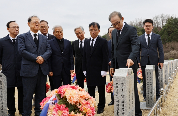 이명박 전 대통령이 25일 국립대전현충원 천안함 46용사 묘역을 찾아 참배 후 묘비를 살펴보고 있다. 2024.3.25 연합뉴스
