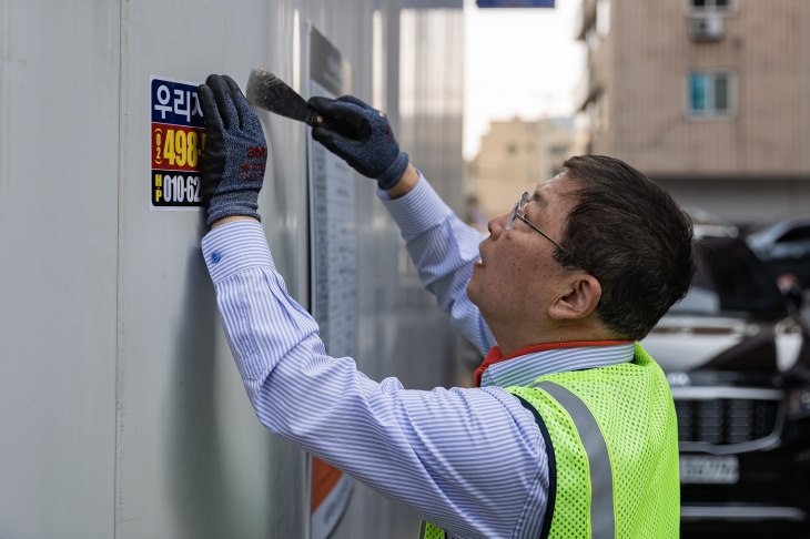 김경호 서울 광진구청장이 ‘봄맞이 대청소’를 진행하며 광고 스티커를 제거하고 있다. 광진구 제공