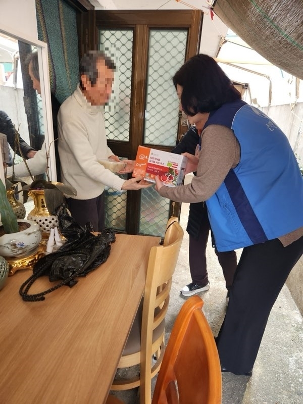 서울 강서구 화곡동의 지역봉사단체 회원이 저소득층 어르신에게 죽과 선물을 전달하고 있다. 강서구 제공