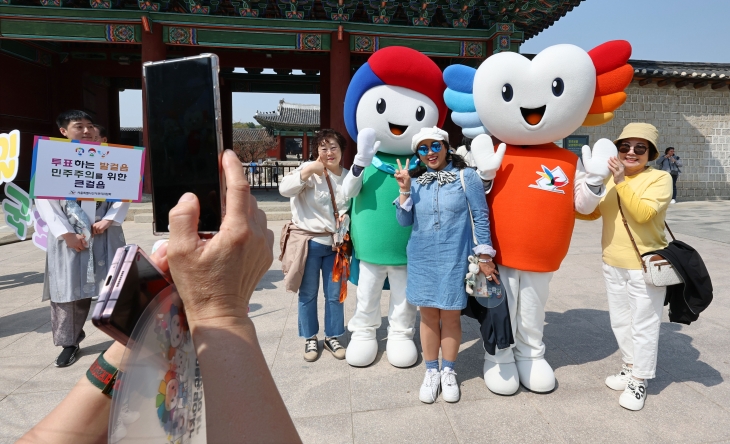 제22대 국회의원선거 투표 참여 캠페인에 참여한 시민들이 7일 서울 종로구 창경궁 앞에서 캐릭터 인형과 사진을 찍고 있다.  연합뉴스