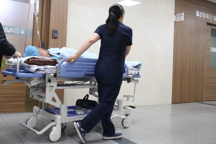 전공의 사직 사태가 지속되며 신규 간호사 발령이 미뤄지고 기존 간호사들은 무급 휴가에 내몰리는 가운데 8일 대구의 한 대학병원에서 간호사가 환자를 태운 침상을 옮기고 있다. 대구 뉴스1